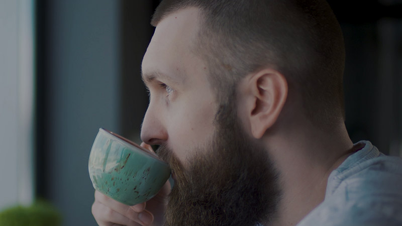 Man drinking coffee. Picture from a video footage.